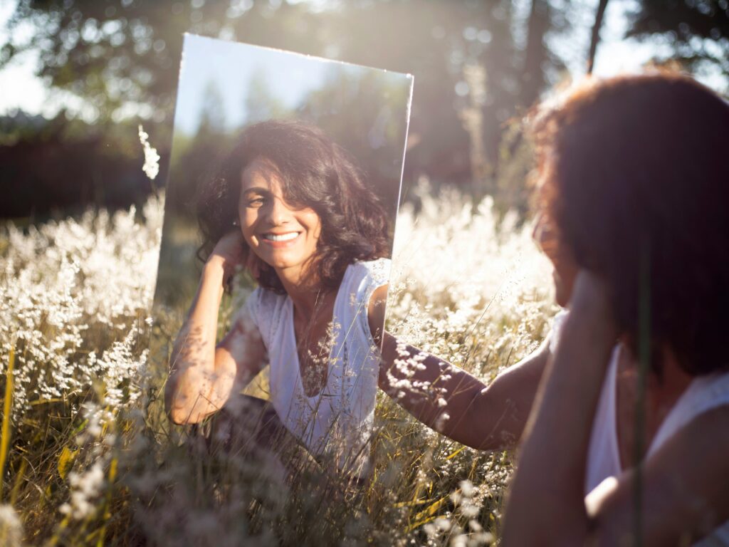 woman smiling at her reflection in mirror